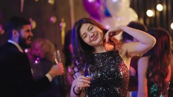 In front of the camera smiling and feeling happy beautiful lady enjoying the time she dancing at glamorous party background other people enjoying the evening — Stockvideo