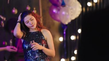 Christmas party atmosphere good looking young lady in a sparkling dress meeting a good friend at the party and start to have a nice conversation they holding a glass of champagne