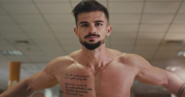 Beau gars athlétique travaillant dur sur le cours de gym concentré il fait des exercices pour ses biceps et triceps — Video