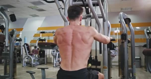 Sport bodybuilding man in a fitness class exercises hard for his back muscle to get more strong and feat body , concentrated doing his workout. 4k