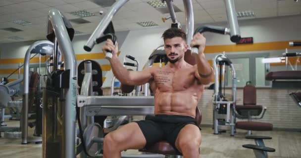 Здоровый образ жизни для сильного мужчины с идеальным телом, которое он тренировал, чтобы получить больше мышц для бицепсов и трицепсов в современном спортзале — стоковое видео