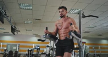 Mükemmel ve terli vücudu olan karizmatik bir genç adam karın kaslarına konsantre olarak güzel bir karın kasına sahip olmak için bacaklarına pompalar.