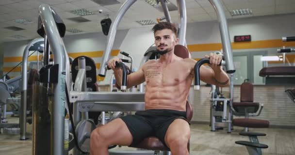 Entrenamiento para un hombre atlético en una clase de gimnasia moderna que ejercita para sus bíceps y tríceps concentrados se vuelve más fuerte y tiene un estilo de vida saludable — Vídeo de stock