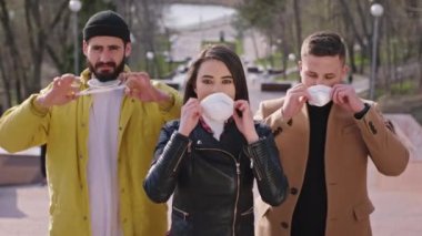 Kameranın önündeki parkın yanındaki öğrencilerin portresi koruyucu maskelerini alıp yeni Covid-19 'u korumak için yüzlerini koyuyorlar. ARRI Alexa Mini 'de çekilen