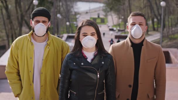 Group of students with protective mask in front of the camera standing beside the park at the stairs they looking straight to the camera new Covid-19 concept — Stock Video