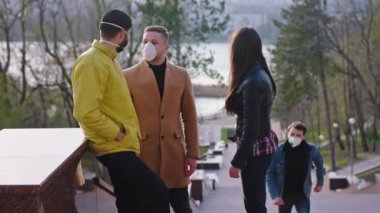 Bir grup çekici arkadaş parkta buluşup Coronavirus saatinde koruyucu maske takıp sohbet ediyorlar.