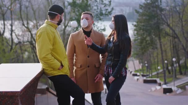 Jovens estudantes têm uma discussão no parque eles conversam através da máscara protetora enquanto está em quarentena do Coronavirus 2019. Tiro em ARRI Alexa Mini — Vídeo de Stock