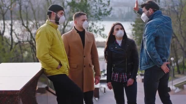 Kelompok siswa yang karismatik berhenti di taman dan mereka berdiskusi untuk menggunakan topeng pelindung untuk melindungi Coronavirus 2019 — Stok Video