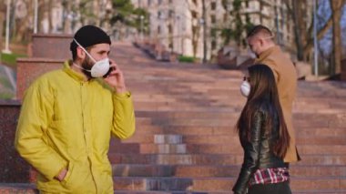 Sokak ortasında bir grup genç insan ve koruyucu maskeli bir adam Coronavirus savaşçılarının karantina zamanında gerildiklerini savunuyorlar. ARRI Alexa Mini 'de çekilen