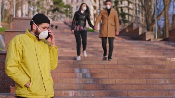 Нова концепція Ковід-19 посередині вулиці хлопець з захисною маскою чхає інші пари відьом, які ходять навколо, побоюючись, що вони носять захисну маску. Розстріляний на ARRI Alexa Mini — стокове відео