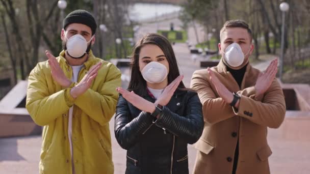 Karismatiska studenter framför kameran visar stopp Coronavirus virus de bär skyddsmask medan de är utanför bredvid parken — Stockvideo