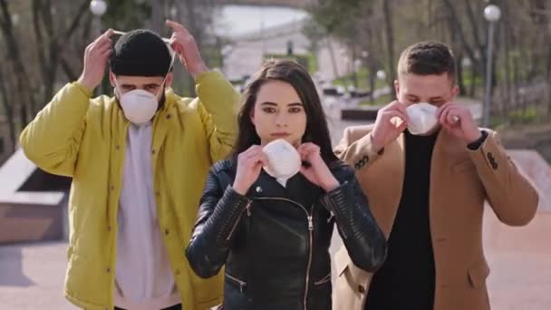 Groep jonge studenten met het beschermende masker terwijl ze voor de camera staan, staan ze buiten naast het Coronavirus 2019 concept — Stockvideo