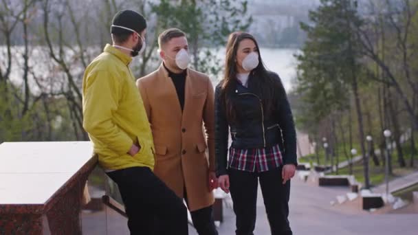 Een groep vrienden in het park nemen een frisse neus ze kletsen samen en dragen alle beschermende masker terwijl is quarantaine nieuwe Covid-19 — Stockvideo