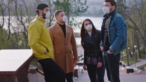 Group of friends in the middle of the park have a conversation together they wearing the protective mask to protect of the Coronavirus mers — Stock Video