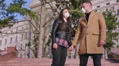Coronavirus 2019 karantinasındayken, boş bir caddenin ortasında, doğrudan kameraya bakan bir çift koruyucu maske takıyor. ARRI Alexa Mini 'de çekilen
