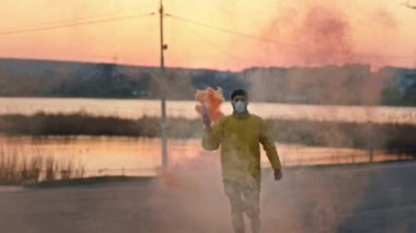 Bombayı elinde tutarken ve koruyucu maske takarken boş parkın ortasında koşan adam Çin 'deki Covid-19 Coronavirus salgınının önünde duruyor.
