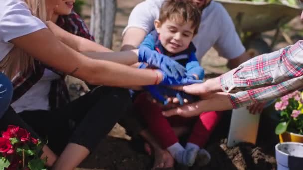 Bahçedeki işi bitirdikten sonra mutlu ve heyecanlı bir aile ellerini kaldırdı ve işlerini bitirdikten sonra mutlu bir şekilde ayağa kalktı. — Stok video