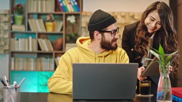 Sonriendo grandes dos trabajadores de oficina delante de la cámara que chatear entre sí y tratar de resolver algunos problemas que son muy disfrutar del trabajo — Vídeo de stock