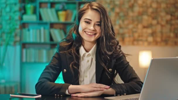 Харизматичная улыбающаяся большая молодая женщина на своем рабочем месте в офисе смотрит прямо в камеру и чувствует себя таким взволнованным — стоковое видео