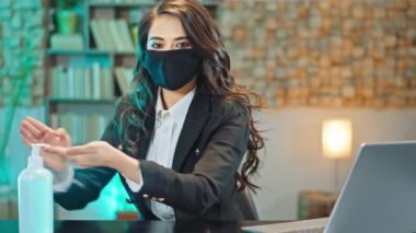 Ofisteki karantina zamanında çalışan bayan dezenfekte edilmiş jeli alıp kendini Coronavirus virüsünden korumak için ellerine sürmüştü. Koruyucu maske takıyordu.