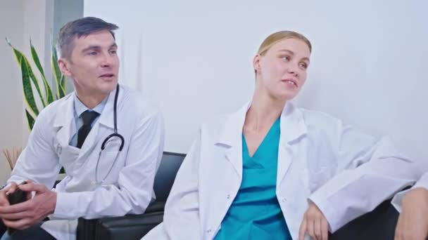 På sjukhuset i grejer rummet grupp av läkare med ett stort leende har en paus tid de umgås spela några spel på den digitala surfplattan — Stockvideo