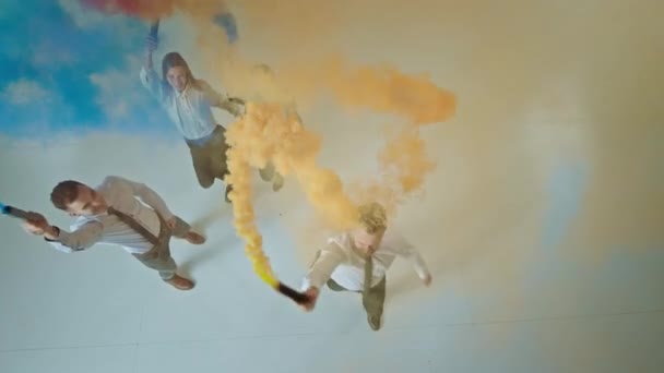 Funny time for group of business center inside of white studio using smoke bomb to have a crazy atmosphere taking video from the top to down — Stock Video