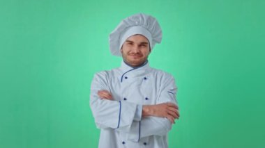 Çekici fırıncı kameranın önünde poz veriyor. Yeşil bir stüdyoda el ele tutuşuyor. Kocaman bir gülümsemesi var.