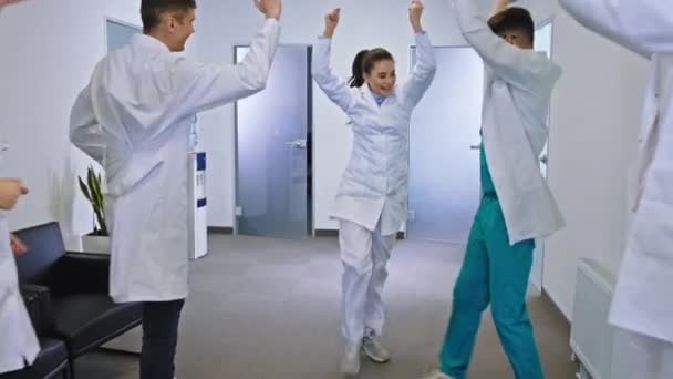 Przerwa w nowoczesnym korytarzu szpitalnym Lekarze i pielęgniarki zespół taniec i uśmiech duże uczucie bardzo podekscytowany i szczęśliwy — Wideo stockowe