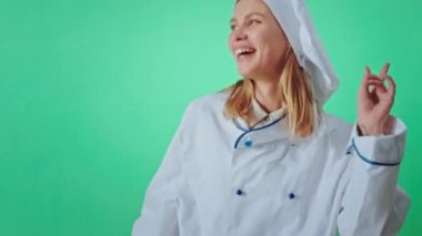 Krom anahtar kavramı güzel fırıncı kadın kameranın önünde dans ediyor büyük, mükemmel bir gülümsemesi var doğrudan kameraya bakıyor. ARRI Alexa Mini 'de çekilen