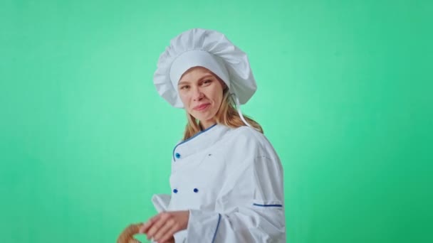 Портрет красивой женщины-пекаря, широко улыбающейся, глядя прямо в камеру и чувствуя себя очень счастливой и взволнованной в зеленой концепции студии. 4k — стоковое видео