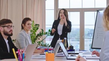 Genç bayan takım liderinin iş arkadaşlarıyla bir toplantısı var. Hep birlikte bazı liderlik fikirlerini analiz edip birlikte oy veriyorlar.