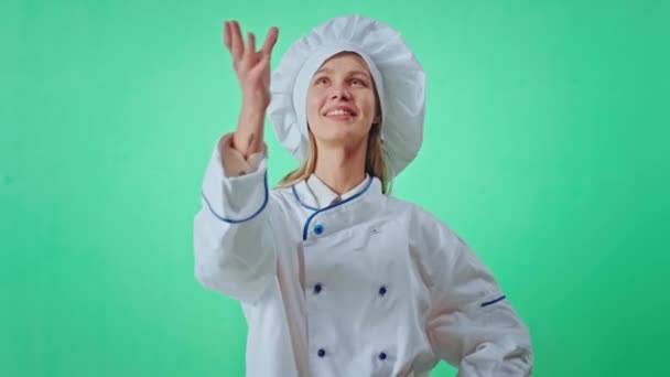 Retrato de atraente carismático padeiro mulher verde estúdio olhando direto para a câmera jogar um pretzel, em seguida, segurando e começar a comer olhando para a câmera sorrindo grande — Vídeo de Stock