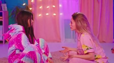 Kameraya yakın bir yerde esmer bir kadın ve arkadaşı esmer bir bayanla sohbet ediyor. Üzülüyorlar. Tek boynuzlu bir pijama giymiş sarışın bir kadın tatlı arkadaşına sarılıyor.