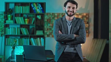 Kameranın önünde mutlu ve karizmatik bir ofis çalışanı. Düzgün bir gülümseme. Günün sonunda rahatlamış ve sevimli.