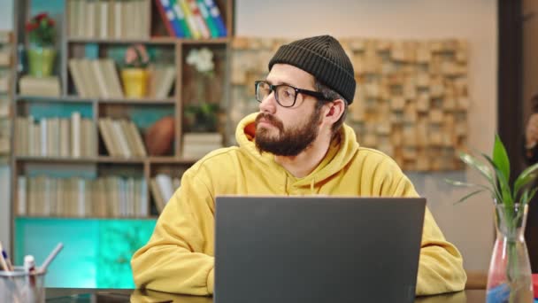 Gut aussehender Kerl in seinem Büro arbeitet an seinem Laptop konzentriert Bürodame bringt die etwas Kaffee zu ihrem Kollegen sie sind Gespräch zusammen Dame nehmen den Laptop etwas zu tippen — Stockvideo