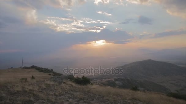 Couple watching sunset on the top of the mountain on rock — Stock Video