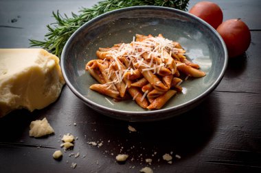 Ahşap masa üstüne Parmesan ile domates Penne makarna