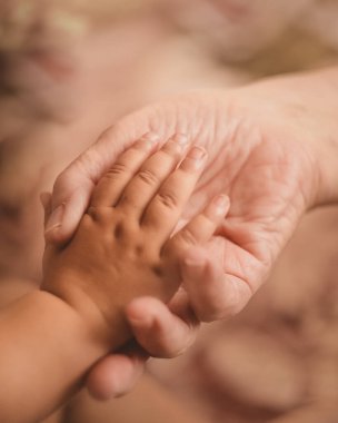 Büyükanne torununun elini avucunda tutuyor.