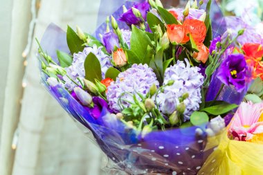 Şirin ve renkli bir demet leylak, menekşe ve turuncu çiçek.