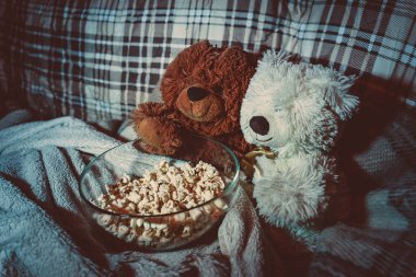 Teddy Bears watch movies on the couch and eat popcorn clipart