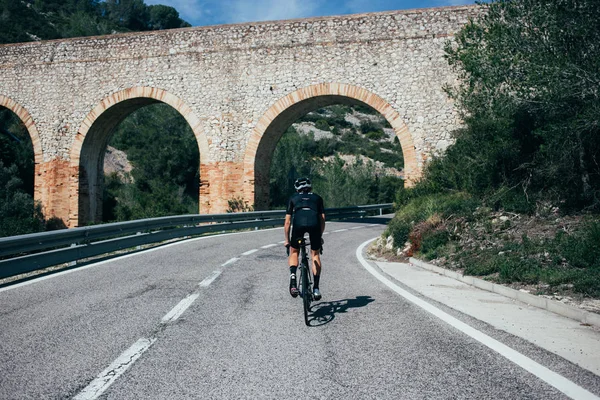 Ciclista in tutto nero cavalcando in Spagna — Foto Stock