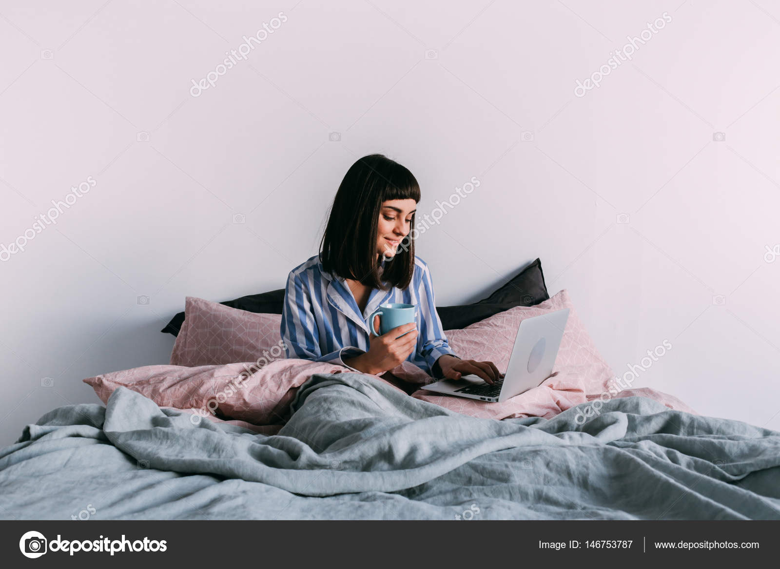 Hipster Girl Lounging In Bed With Coffee Stock Photo