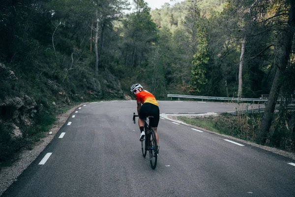 Mujer ciclista montando en las montañas y árboles de España — Foto de Stock