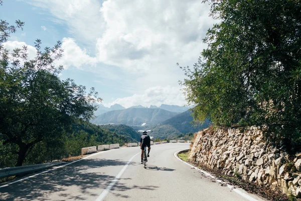 Велосипедист быстро едет в горы — стоковое фото