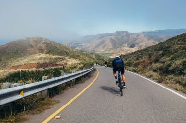 Rüzgarlı road azalan bisikletçiler grup  