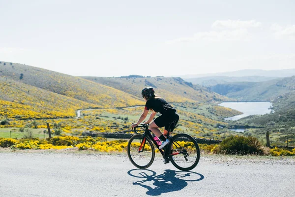 Жінка-велосипедистка катається на заході сонця — стокове фото