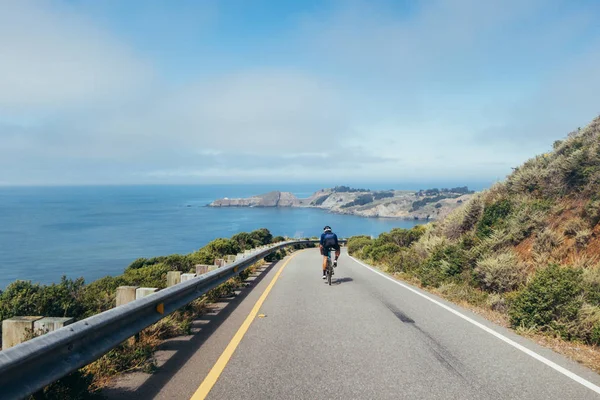 Grupo de ciclistas descendiendo por carretera ventosa — Foto de Stock