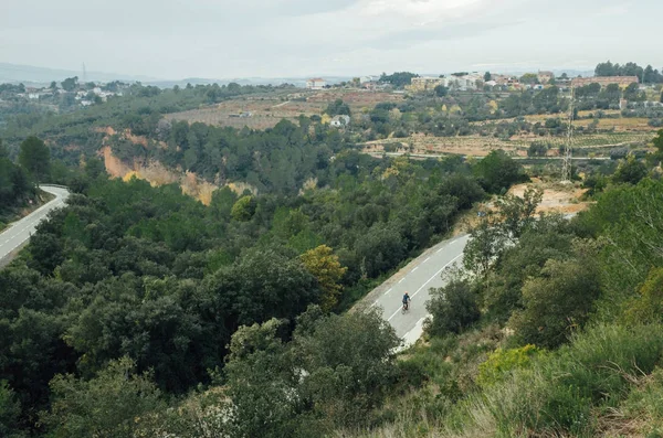 Ποδηλάτης ανεβαίνει πολύ ορεινό δρόμο Εικόνα Αρχείου