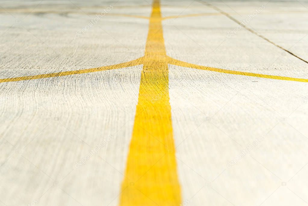 Yellow direction strips closeup on an airfield runway.