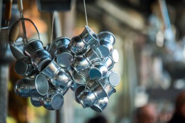 Parlak metal ayran (Ayran - geleneksel Türk yoğurt içki) grupları Kapalı Çarşı yakınlarında bir eski geleneksel mağaza önünde asılı bardak içme.